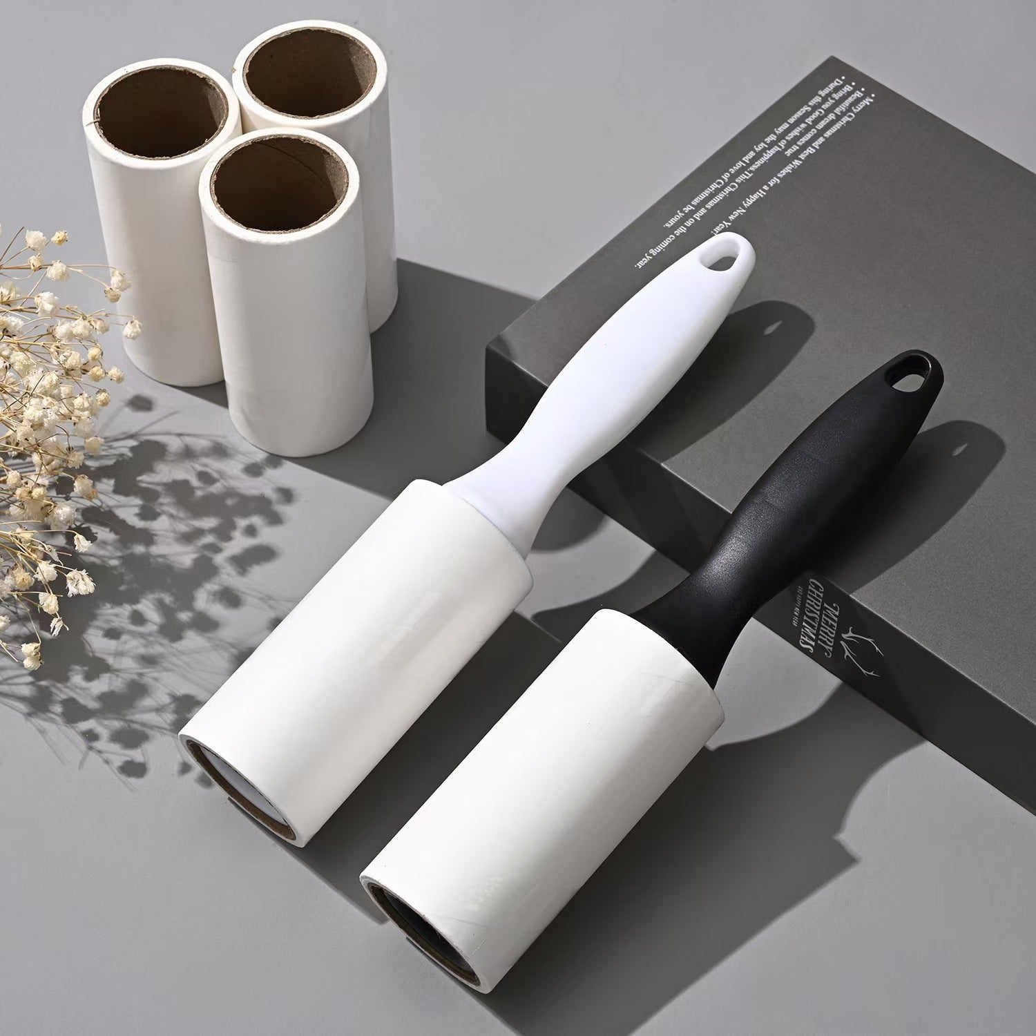 Tearable Lint Remover with black and white handles, perfect for removing pet hair and lint from surfaces.