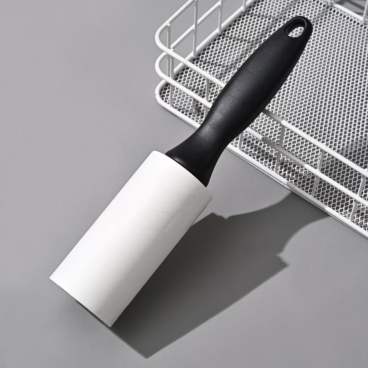 Tearable Lint Remover roller on a gray surface, designed for cleaning lint and pet hair from various surfaces.