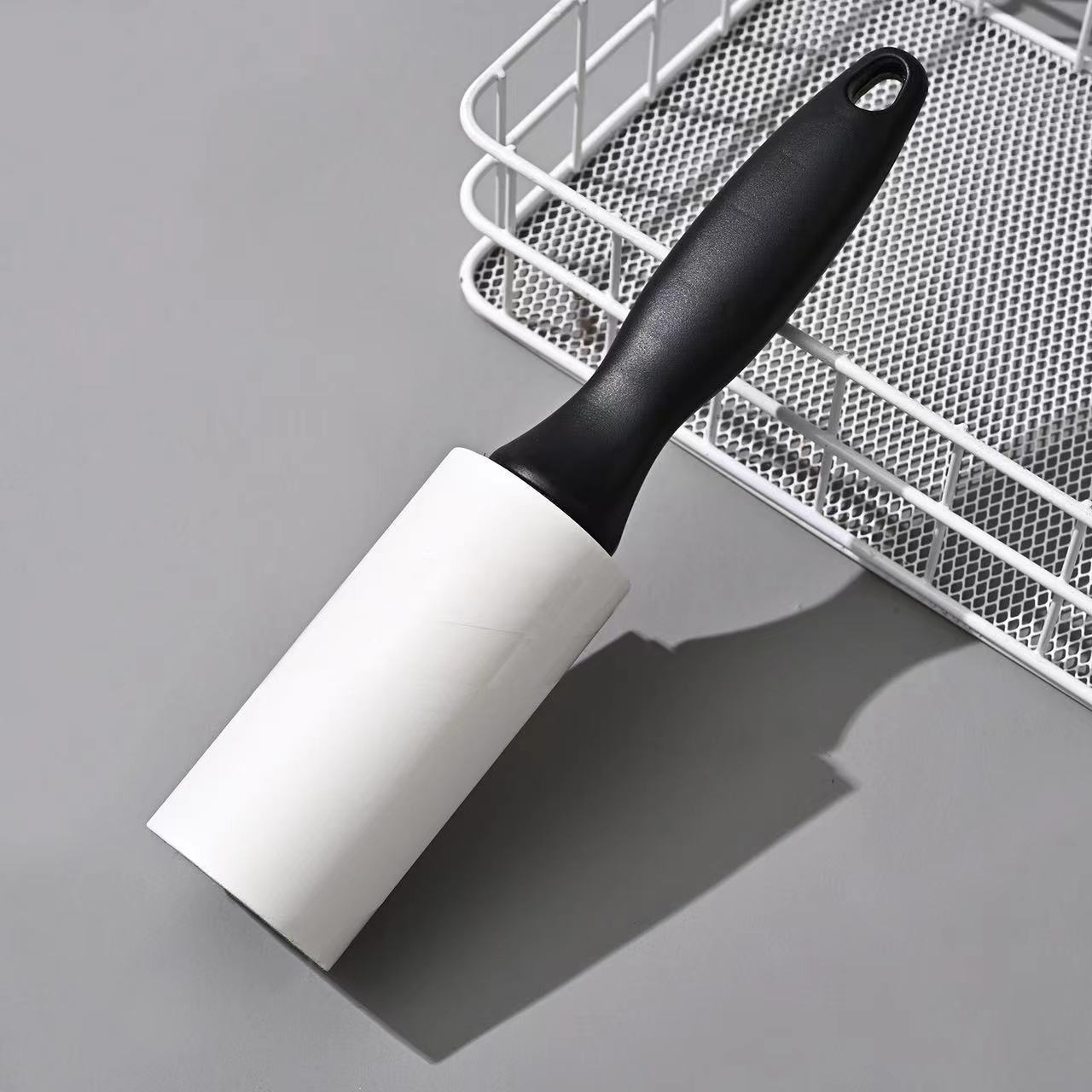 Tearable Lint Remover roller with a black handle, designed for removing lint and pet hair from surfaces.